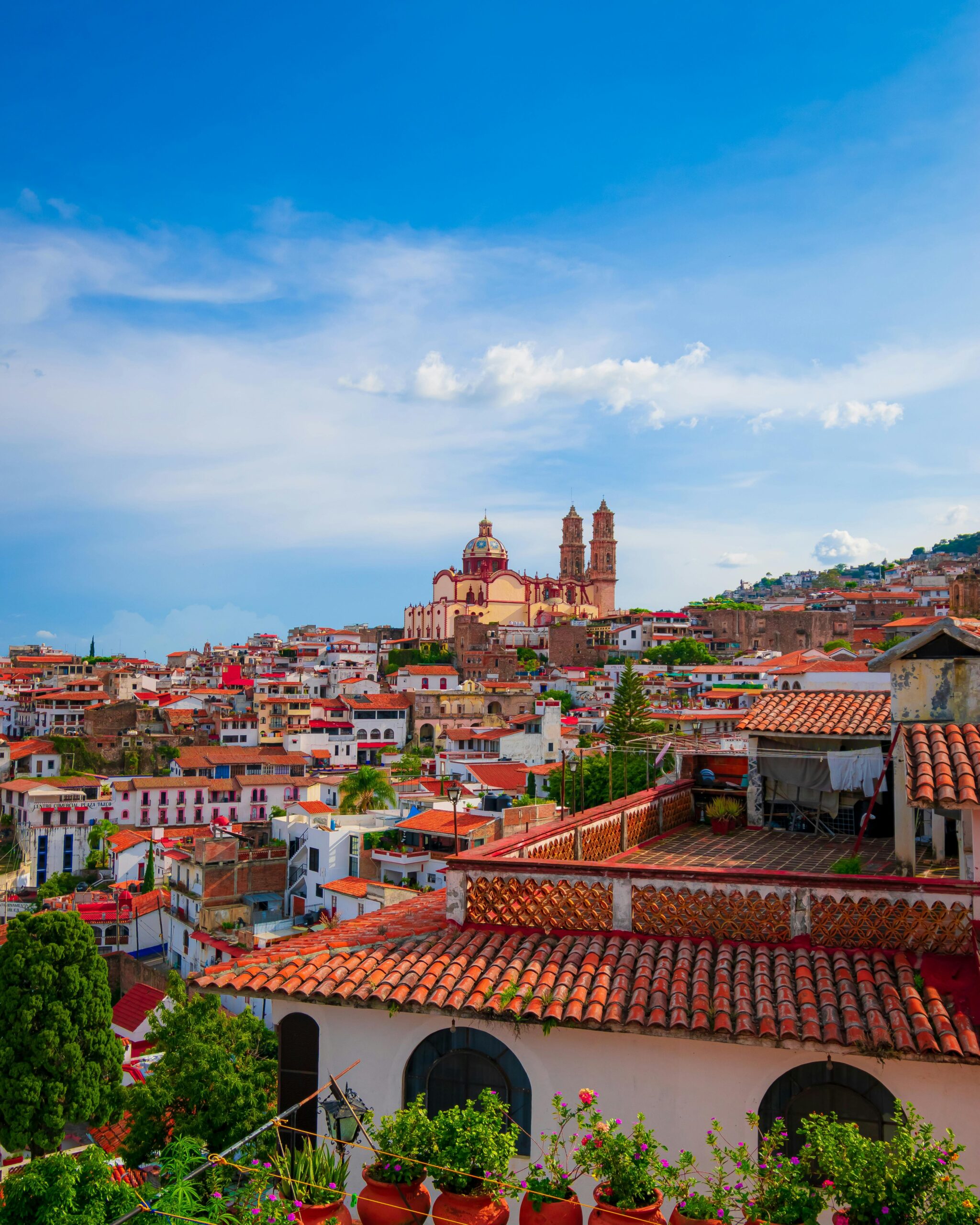Charming aerial view of Taxco's traditional architecture against a vibrant blue sky.